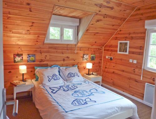 a bedroom with a bed in a log cabin at Appartement 2 chambres Bassin d'Arcachon front de mer, plage du Betey in Andernos-les-Bains