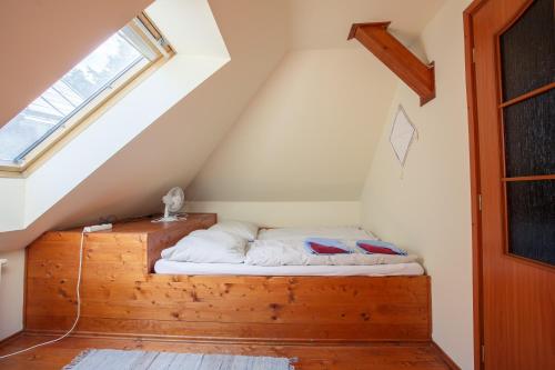 a bedroom with a wooden bed in a attic at Penzión Príjemný Oddych in Banská Štiavnica