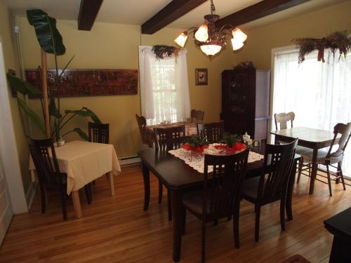 - une salle à manger avec une table et des chaises dans l'établissement Au Manoir de la rue Merry, à Magog