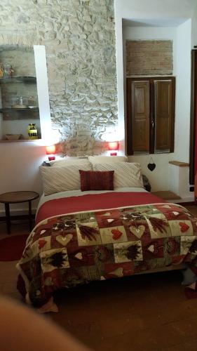 a bedroom with a bed and a stone wall at La Torretta - Cerreto Grue in Sarezzano
