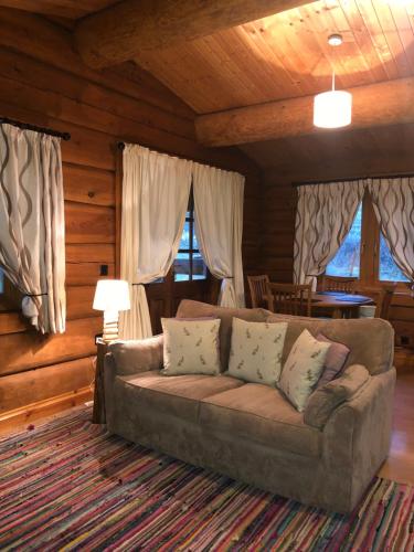 a living room with a couch in a log cabin at Log home village in Ulverston