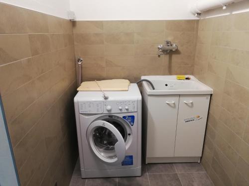 a laundry room with a washing machine and a sink at Casa Mirandola Montana in Commezzadura