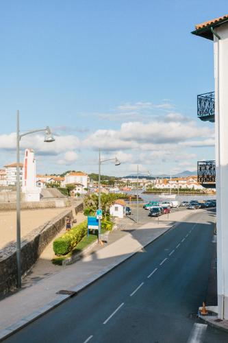 an empty road with a city in the background at Hôtel La Caravelle in Ciboure