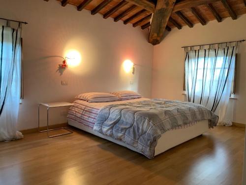 ein Schlafzimmer mit einem Bett und zwei Fenstern in der Unterkunft Casa Cinzia in Castellina in Chianti
