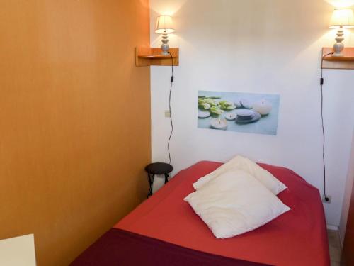 - une chambre avec un lit rouge et un oreiller blanc dans l'établissement Apartment Le Beach.3, à Canet