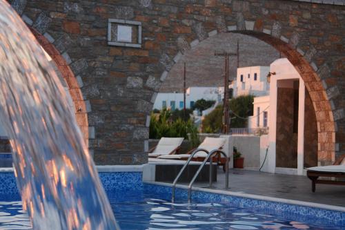 a swimming pool with an archway and a water fountain at Vigla Hotel in Aegiali