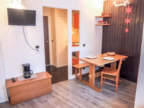 une salle à manger avec une table et une télévision dans l'établissement Apartment Armoise 51 by Interhome, aux Menuires