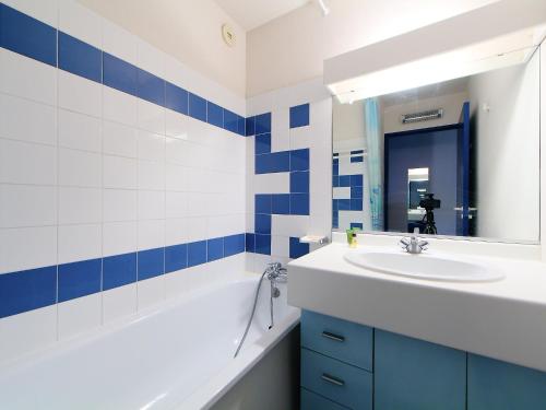 une salle de bain avec un lavabo, une baignoire et un miroir dans l'établissement Apartment La Palme d'Or-12 by Interhome, au Cap d'Agde