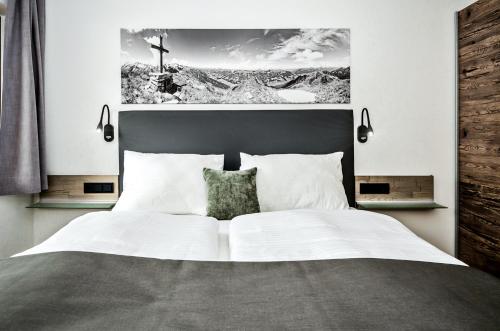 sypialnia z dużym łóżkiem z plakatem na ścianie w obiekcie Appart-Pension Schnöll w mieście Mittersill