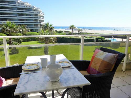 - une table avec des assiettes de nourriture sur le balcon donnant sur la plage dans l'établissement Apartment Grand Sud-4 by Interhome, à Canet
