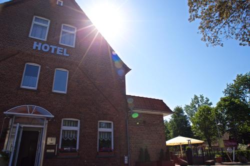 a brick hotel building with the sun shining on it at Neumanns Waldschänke in Soltau