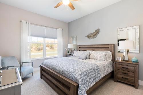 a bedroom with a bed and a chair and a window at Summerville Vacation Resort in Orlando