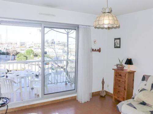 d'un salon avec une porte coulissante en verre s'ouvrant sur un balcon. dans l'établissement Apartment Les Marines de Port Canet by Interhome, à Canet