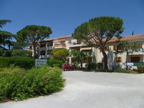 a car parked in a parking lot next to a building at Apartment Provence Village-1 by Interhome in Saint-Cyr-sur-Mer