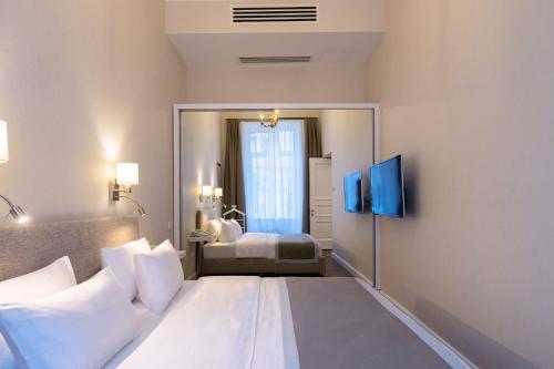 a bedroom with a large white bed and a mirror at TIFLIS OPERA Aparthotel in Tbilisi City