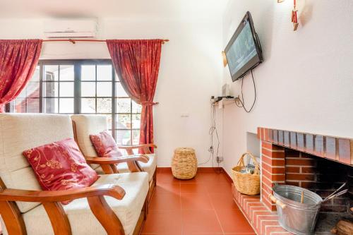a living room with a fireplace and a tv at Altura Inn Cottage in Altura