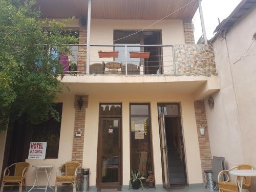 a house with a balcony with a table and chairs at Old Capital in Mtskheta