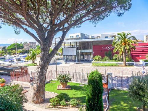 un arbre en face d'un bâtiment avec un parking dans l'établissement Apartment Port Quiétude-4 by Interhome, à Fréjus