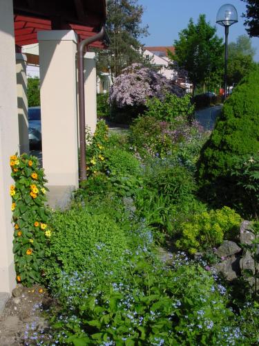 a garden of flowers in front of a house at Aparthotel Grabner in Bad Füssing