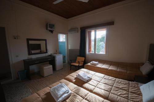 a hotel room with two beds and a television at Avaton Hotel in Lygourio