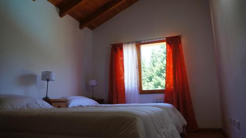 sypialnia z 2 łóżkami i oknem w obiekcie ROSALES Alojamiento w mieście Villa La Angostura