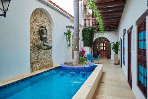 a swimming pool in a house with a fountain at Cartagena Legends in Cartagena de Indias