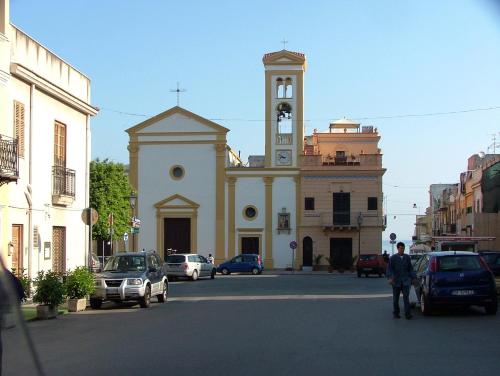 a large building with a clock tower on a street at Casa sul mare in Isola delle Femmine