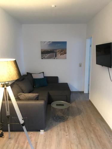 a living room with a couch and a flat screen tv at Apartments Benser-Hof in Bensersiel