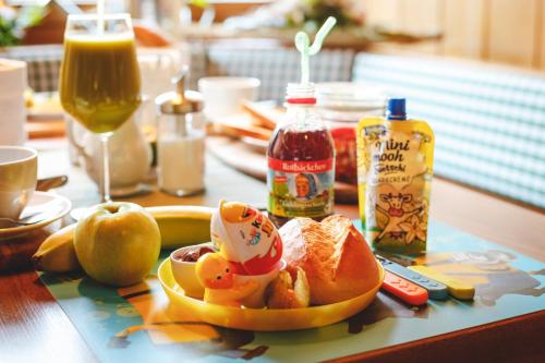 a table with a plate of fruit and a drink at Pension Dorfliebe in Sondershausen