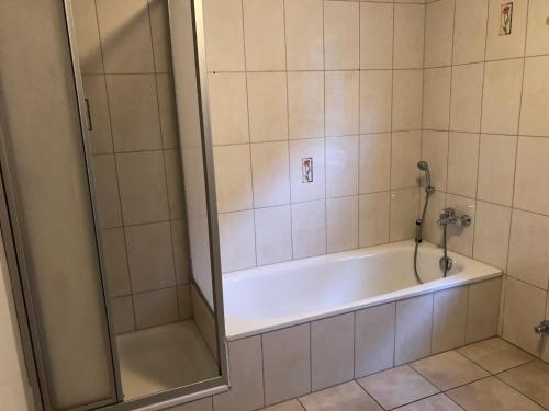La salle de bains est pourvue d'une douche et d'une baignoire. dans l'établissement Holstengang 32 1 Zimmer FEWO, à Flensbourg