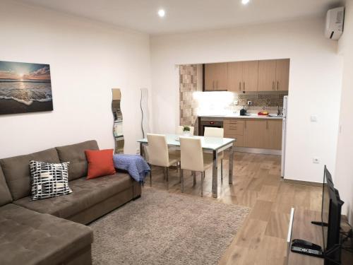 a living room with a couch and a table and a kitchen at Sonetos do Sado in Setúbal