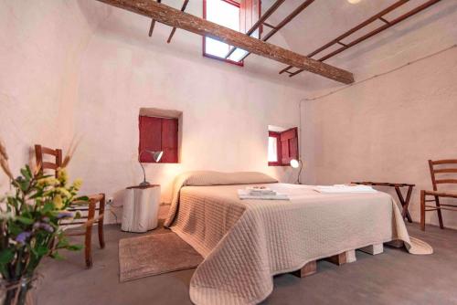 a bedroom with a bed and two chairs in a room at Masseria Spina Resort in Monopoli