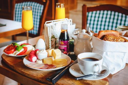a table with plates of breakfast food and a cup of coffee at Pension Dorfliebe in Sondershausen