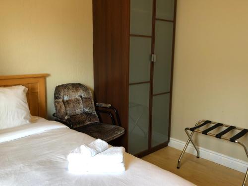 a hotel room with a bed and a chair at Cozy Bedrooms Guest House in Vancouver