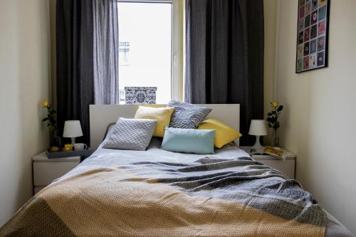 sypialnia z łóżkiem z poduszkami i oknem w obiekcie Apartamenty KDN na Rysiej w mieście Katowice