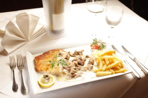a plate of food with meat and fries on a table at Neumanns Waldschänke in Soltau