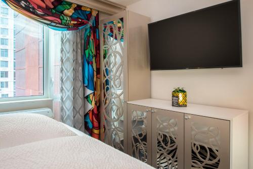 a bedroom with a bed and a flat screen tv at Staypineapple, An Artful Hotel, Midtown New York in New York
