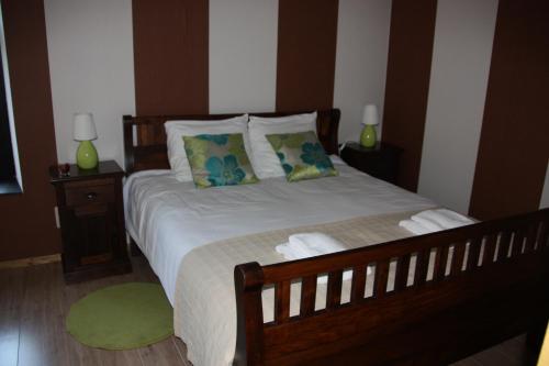 1 dormitorio con 1 cama con 2 lámparas y alfombra verde en B&B Des4seigneurs, en Gedinne