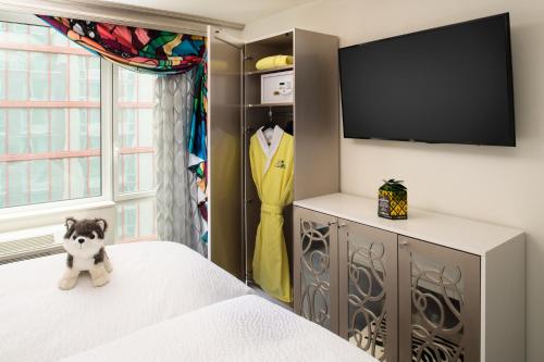 a bedroom with a dresser with a tv and a bed at Staypineapple, An Artful Hotel, Midtown New York in New York