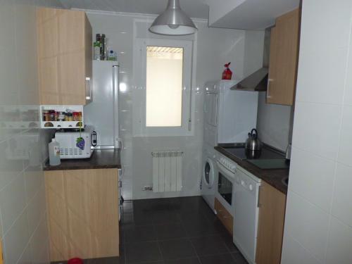 eine kleine Küche mit weißen Geräten und einem Fenster in der Unterkunft Apartamento Rio Lavilla in Castañares de Rioja