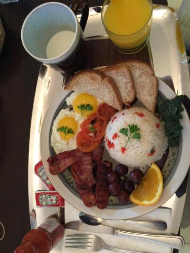 a plate of breakfast food with eggs sausage and bread at Cozy Bedrooms Guest House in Vancouver