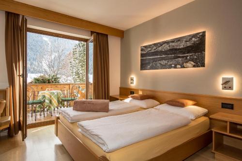 ein Hotelzimmer mit 2 Betten und einem Balkon in der Unterkunft Residence Sas Vanna in Stern