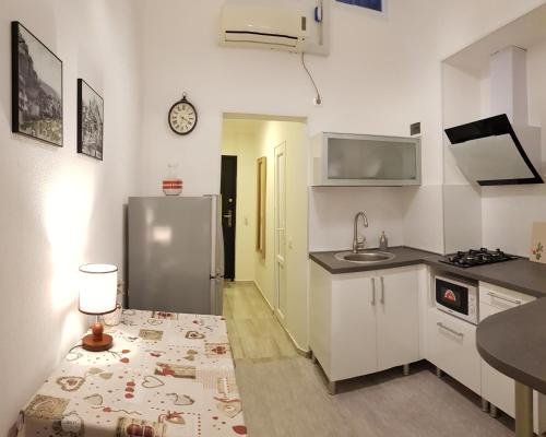a kitchen with a refrigerator and a table with a lamp at Cozy Apartment in Old Tbilisi in Tbilisi City