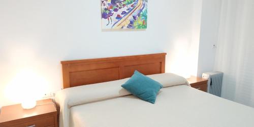a bedroom with a bed with a blue pillow on it at Kiana Mirador Puerto Sherry con parking in El Puerto de Santa María