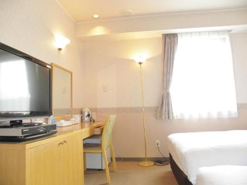 Habitación de hotel con cama y escritorio con TV. en Yonezawa - Hotel / Vacation STAY 14344, en Yonezawa