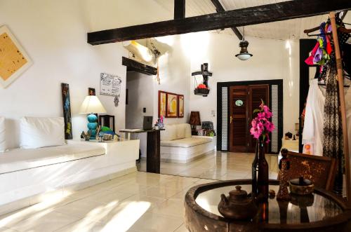 sala de estar con muebles blancos y mesa en Pousada Bela Casa Geribá, en Búzios