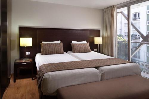 pokój hotelowy z dwoma łóżkami i dużym oknem w obiekcie Exe Suites Reforma w mieście Meksyk