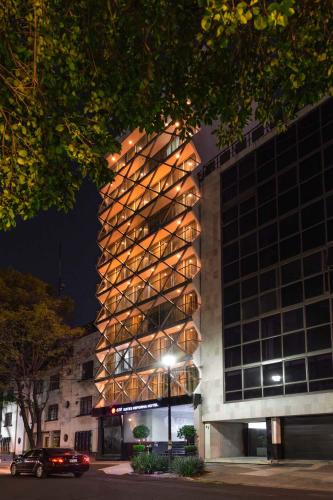 a building with a lit up facade at night at Exe Suites Reforma in Mexico City