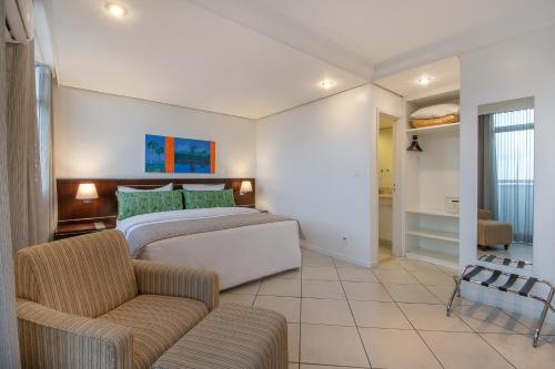 a bedroom with a bed and a couch at Manaus Hotéis Millennium in Manaus