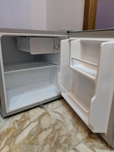 an empty refrigerator with its door open in a kitchen at Tahrir Square Hostel in Cairo